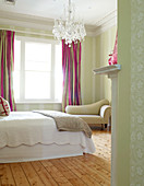 Bedroom with crystal chandelier and simple wooden floor