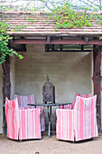 Kleiner Terrassenplatz mit antiker Laterne auf dem Tisch und Stühlen mit Hussen