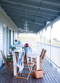 Simple table and chairs on the veranda of a wooden country home