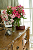 Vase of flowers on antique, wooden chest of drawers