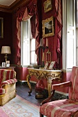 Artistic interior in old English salon with walls and pelmets in shades of pink and Rococo console table