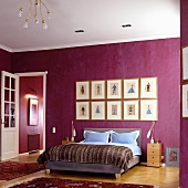 Bedroom with double bed against wall painted deep violet in traditional setting