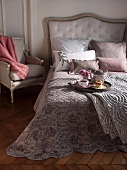 Breakfast tray on comfortable bed with upholstered headboard