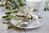 A Christmas place setting with mistletoe and a snowflake