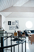 Künstlerischer Loft-Wohnraum im Vintagestil mit weiss verschaltem Zeltdach und Wendeltreppengeländer im Vordergrund