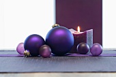 Purple Christmas tree baubles and candle