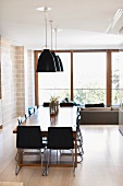 Dining room with long dining table and pendant lamps