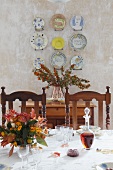 View across festively set table to wall plates mounted on plastered wall