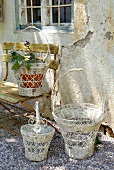 Nostalgic flower baskets and garden bench against weathered facade