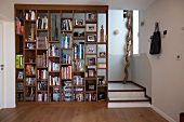 Bücherregal als Raumteiler vor Treppe