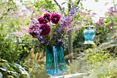 A bunch of summer flowers and a lantern in a garden