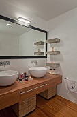 Minimalist designer bathroom with white ceramic basins on wooden counter and wall-mounted mirror