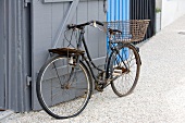 Rusty vintage bicycle leaning on wooden gate