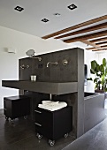 Freistehende Installationswand mit Badewanne und Waschtisch grau gefliest in loftähnlichem Raum