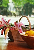 Dish of lemons and wooden trug of lilies