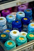Spools of thread in various shades of blue in storage box