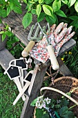 Gardening tools and work gloves on rustic wooden stool in garden