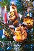 Animal-shaped baubles hanging on Christmas tree