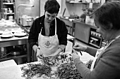 Women sorting herbs in kitchen