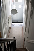Blick von Treppe auf moderne Hängelampe in Jugendstil Hauseingang