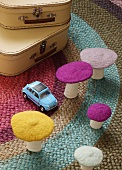 Decorative felt mushrooms and toy car on rug