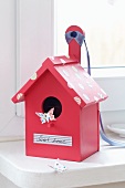 Romantic, pink bird box with label reading 'Sweet home' and tape spots