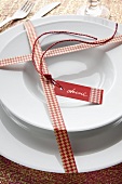 Plates decorated for Christmas with a name tag and wrapped with masking tape