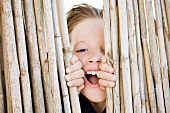 Close up of boy smiling behind fence