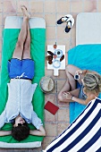 Couple relaxing on beach mats