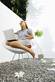 Woman sitting outdoors using laptop