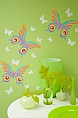 Green vases against wall with green wallpaper and spring-themed wall stickers