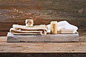 Spa decoration in natural tones - massage belt, natural sea sponge and block of soap on wooden board
