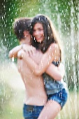 Couple hugging under sprinkler