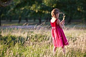 Girl picking ears of wheat in field