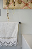 Romantisches Handtuch unter stoffgepolstertem Schmuckboard im Landhausstil