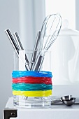 Glass container of kitchen utensils used as holder for rubber bands