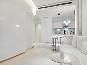 Designer Wohnraum in Weiß mit offener Küche vor geschwungener Wand
