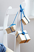 Small parcels tied with cord hanging from back of chair