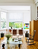 Couchtisch aus Glas auf Rollen und Designer-Stühle im Wohnzimmer