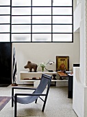 Designer chair in front of sideboard in loft-style apartment