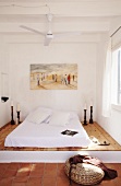 Mediterranes Schlafzimmer mit Matratze auf Podest und Deckenventilatro