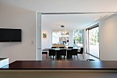 View over breakfast bar to dining table in modern home