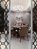 Elegant dining room with chandelier and printed wall paper