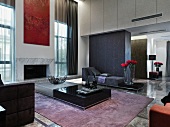 Elegant, designer style living room with low coffee tables on a carpet and a variety of upholstered furniture