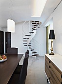 Modern dining area and sideboard in a contemporary living room with spiral staircase