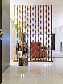 Transparenter Raumteiler aus spiralförmigen Holzleisten im modernen Vorraum