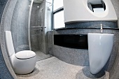 Blick durch Fischauge auf futuristisches Badezimmer aus Beton mit weissen Designer Sanitärobjekten