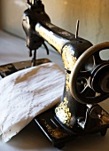 Antique sewing machine and white embroidered fabric