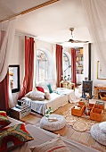Gemütliches Tagesbett mit Kissen am Rundbogenfenster und improvisierter Bodentisch in mediterranem Wohnzimmer