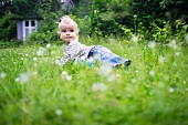 Baby girl crawling in tall grass